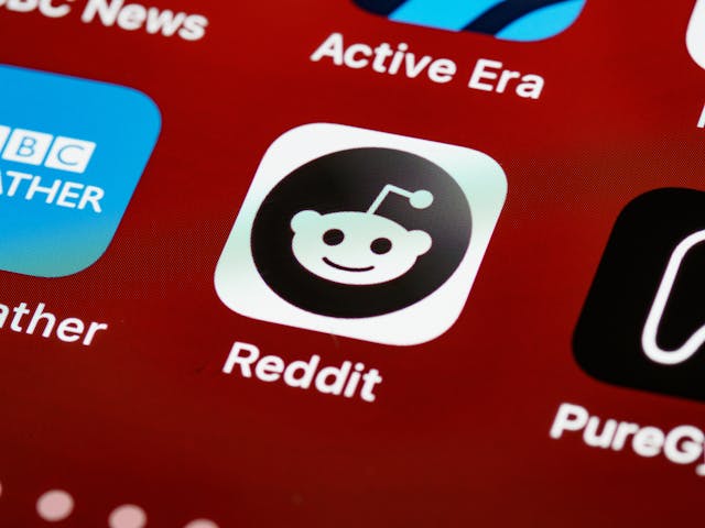 The Reddit app icon on a mobile device screen alongside other application icons like BBC Weather and PureGym.